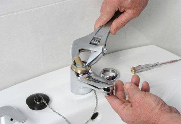 Penstan plumbing & Heating Supply Alottona PA - Trade Professional plumber using a wrench to fix a bathroom sink faucet handle